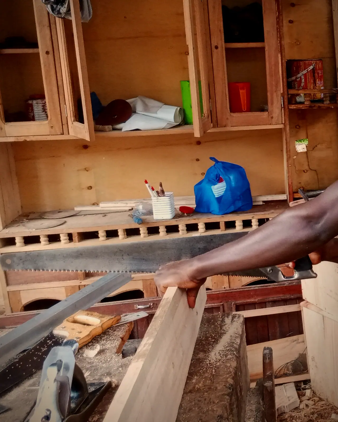 Un compagnon assemblant un cadre de bois dans l'atelier.